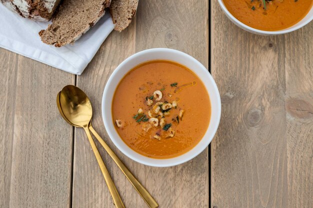 Foto close-up di zuppa di zucca in una ciotola su un tavolo di legno