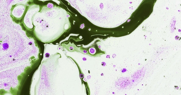 A close up of purple and green paint on a white background