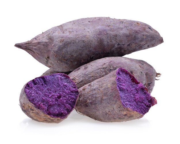 Photo close-up of purple sweet potatoes over white background