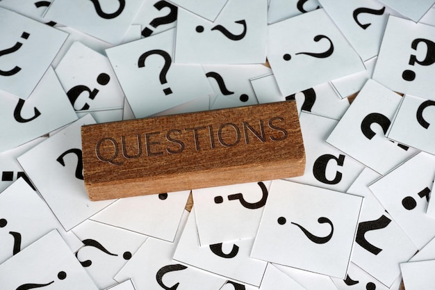 Close-up of question mark sign on papers over table
