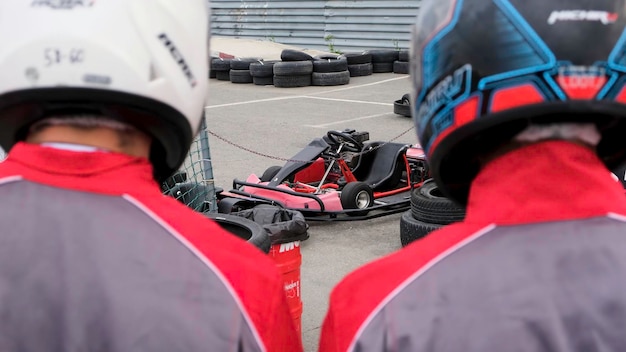 Foto close-up di corridori che indossano uniformi speciali e caschi che vanno alla competizione di kart e