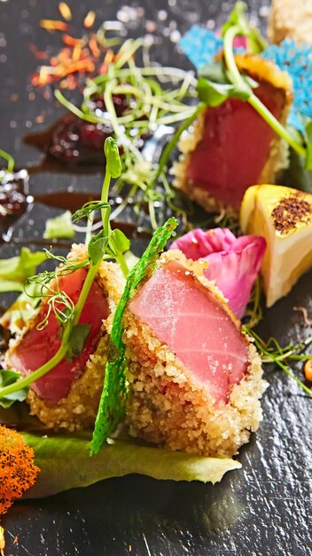 Close up of rare seared Ahi tuna slices with fresh vegetable salad on a plate