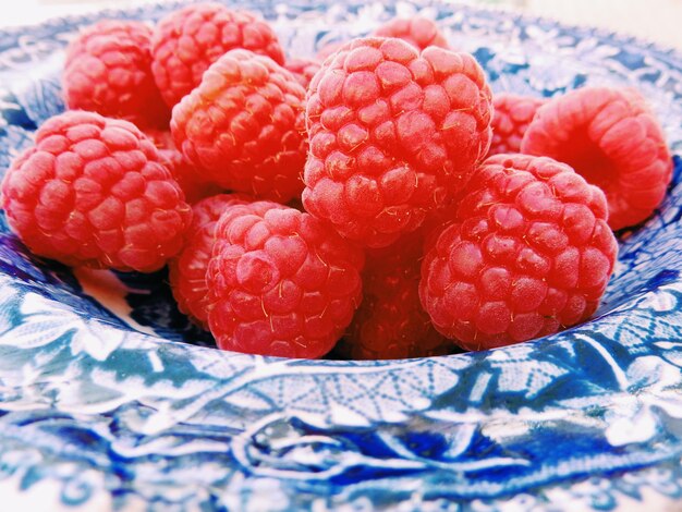 Close-up of raspberries in blue patterned plate