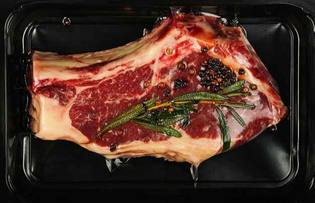 Primo piano bistecca di manzo cruda ribeye sigillata sottovuoto