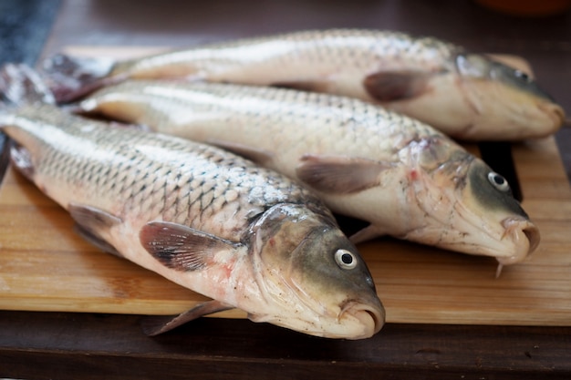 Close up on raw carps on a wooden cutting board