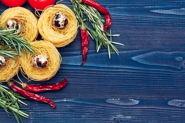 Close up of a raw dry italian pasta fettuccine on blue wooden table