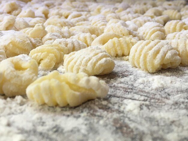 Foto close-up di gnocchi crudi su un tavolo da taglio