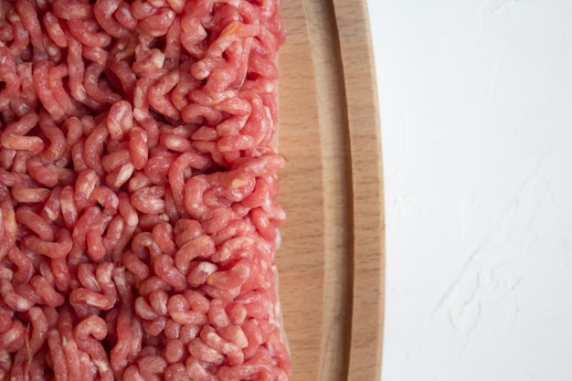 Close up Raw Minced Meat on the cutting Board and kitchen towel on a white table
