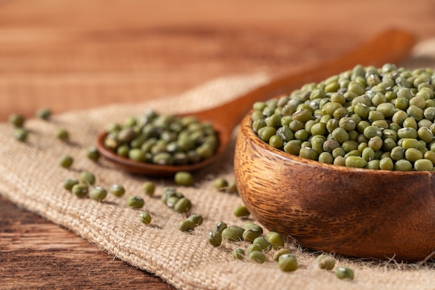 Close up of raw mung bean in a bowl on wooden table background.