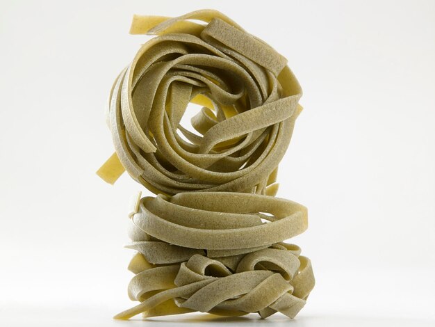 Photo close-up of raw pasta against white background