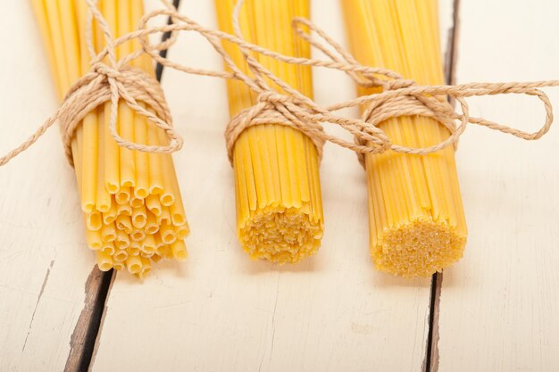 Foto close-up di fasci di pasta cruda su un tavolo di legno