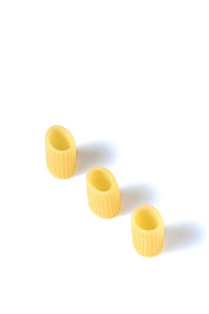 Close-up of raw pasta over white background