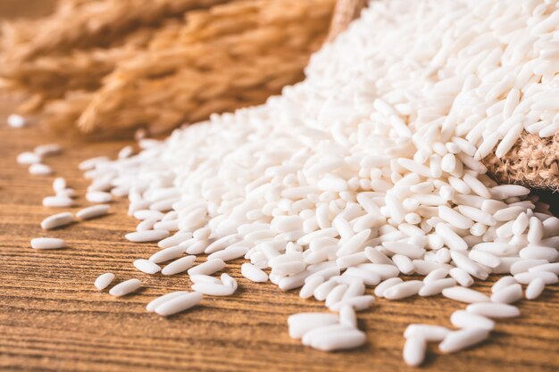 Close up of raw rice on wooden table.