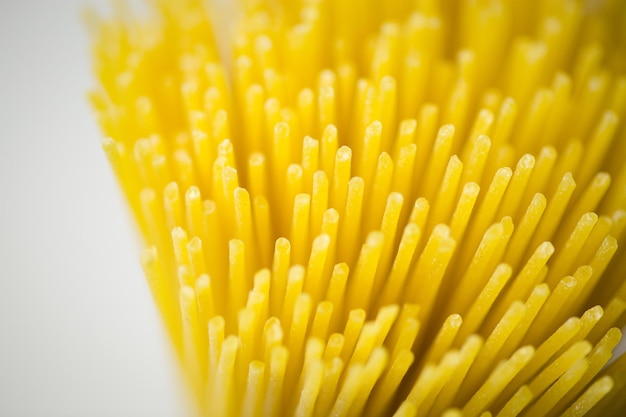 Close-up of raw spaghetti over white background