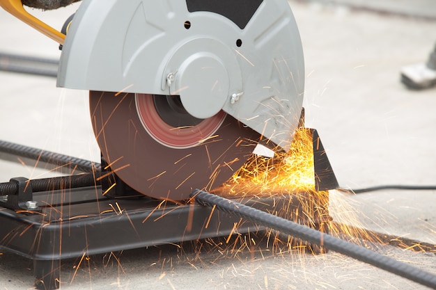 Photo close up of rebar being cut at a construction site. short trail of sparks