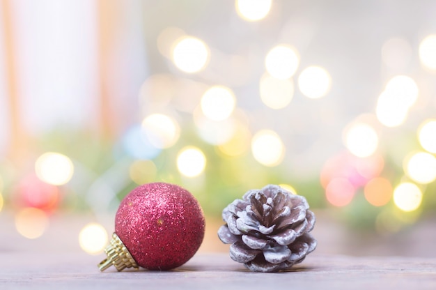 Close up of red ball and pinecone for Christmas on blurred lights