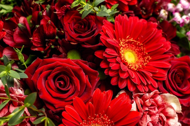 Primo piano di un bouquet di fiori rossi con rose e gerbere.