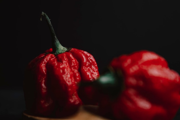 Foto close-up di peperoncini rossi contro uno sfondo nero