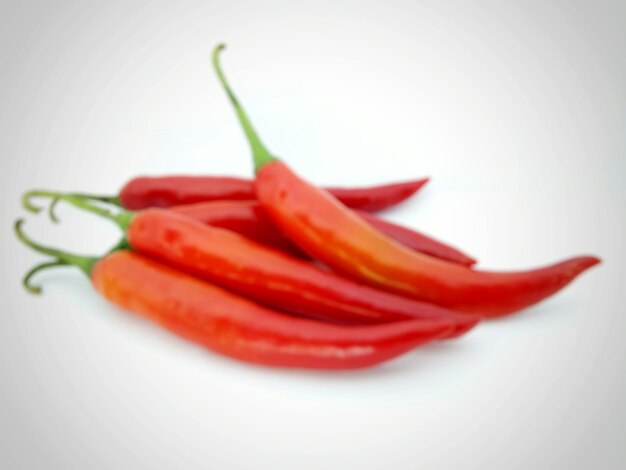 Close-up of red chili peppers over white background