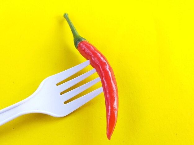 Close-up of red chili peppers on yellow background