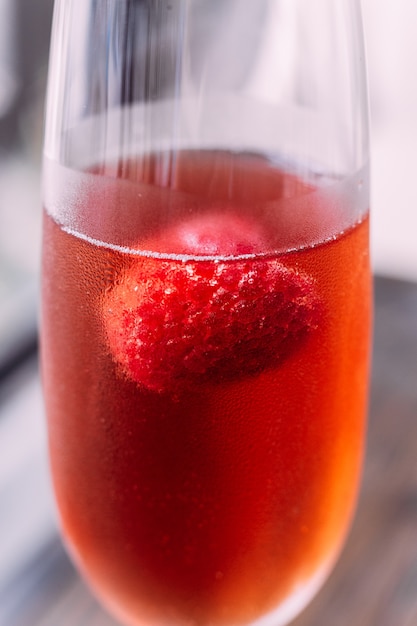 Close up Red cocktail with raspberry inside in glass wine.