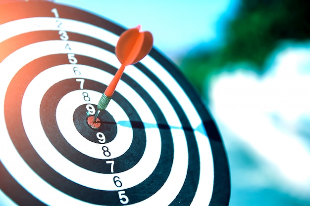 Close up a red color arrow in the center of Bullseye or bull's-eye for business targeting and good success.