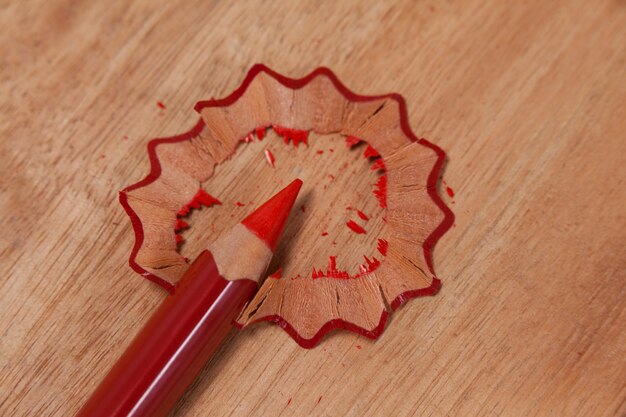 Close-up of red colored pencil with shavings