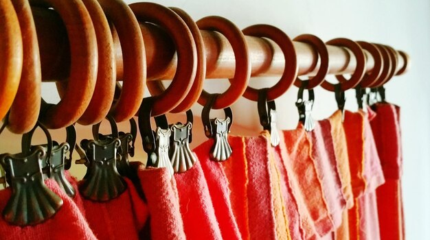 Close-up of red curtain hanging from hooks