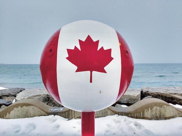 Close-up of red flag on beach against clear sky