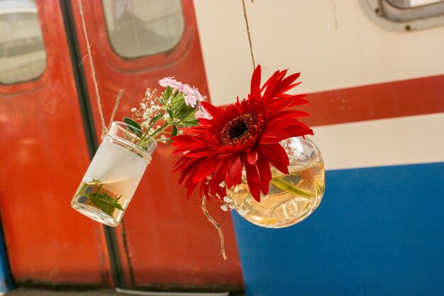 Foto close-up di un vaso di fiori rossi sul tavolo