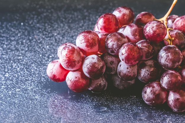 Close up of Red grapes with water drops on black background