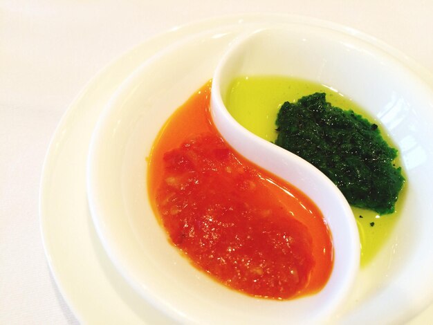 Photo close-up of red and green sauce in container
