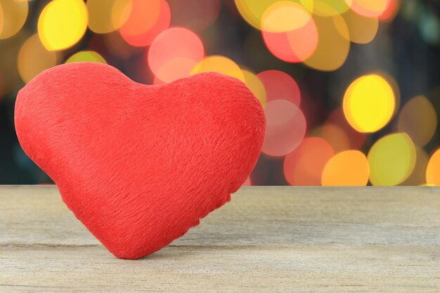 Close-up of red heart shape decoration on table against defocused lights