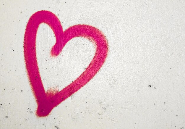 Photo close-up of red heart shape on white wall