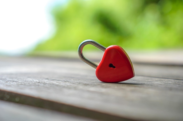 Foto close-up di un lucchetto rosso a forma di cuore sul tavolo