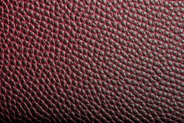 A close up of a red leather texture with a pattern of scales.