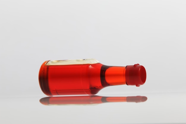 Close-up of red liquid in bottle on white background