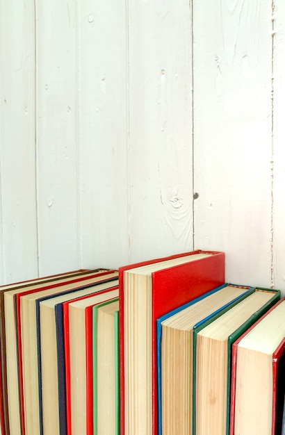 Foto close up libro rosso romanzo estende lo sfondo è un muro di legno bianco.