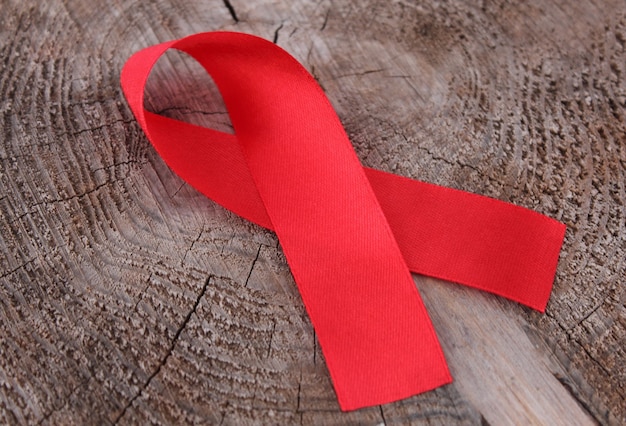 Photo close up red ribbon on a wooden surface