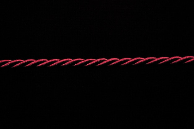 Photo close-up of red rope on black background