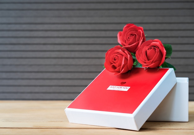 Close up red roses and heart-shaped box on wood background,Valentines Day concept with roses and red heart-shaped box