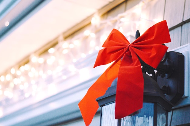 Photo close-up of red tied bow on lamp during christmas