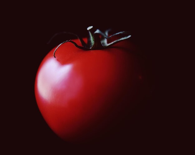 Close-up of red tomato black background