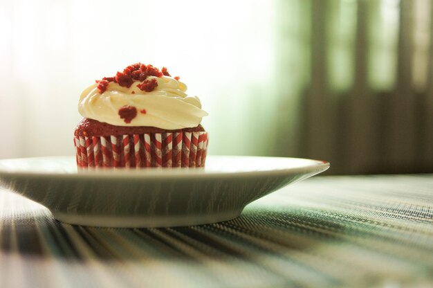 Foto close-up di cupcake di velluto rosso con glassa di formaggio crema sul tavolo