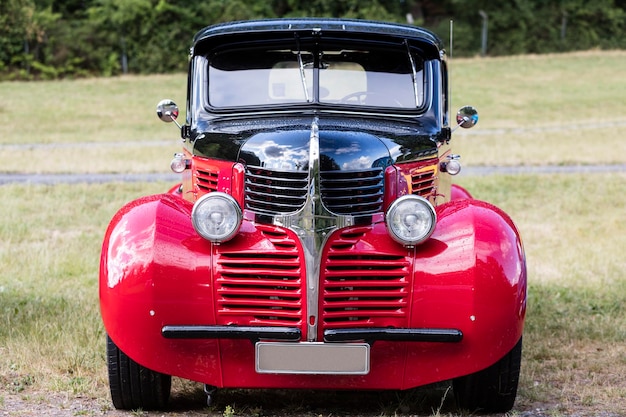 Close-up of red vintage car on field
