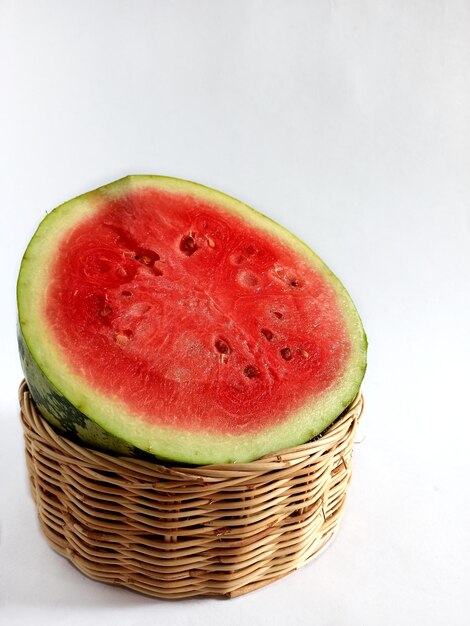 Close-up of red watermelon in wicker basket against white background citrullus lanatus