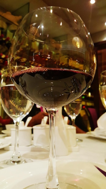 Foto close-up di vino rosso in bicchiere su tavola