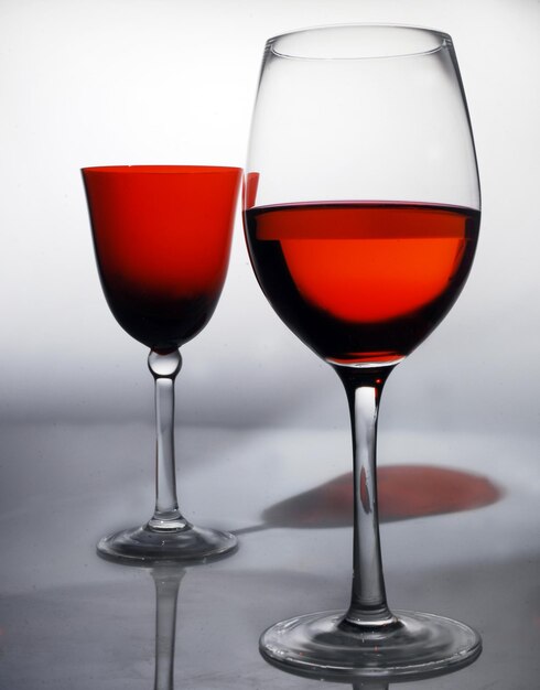 Photo close-up of red wine in glasses against gray background