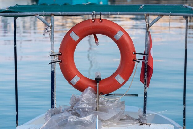 Close-up reddingsboei op een boot Rode reddingsboei op scheepsreling met zee-oppervlak