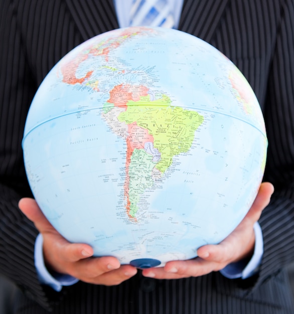 Photo close up of a relaxed businessman holding a globe